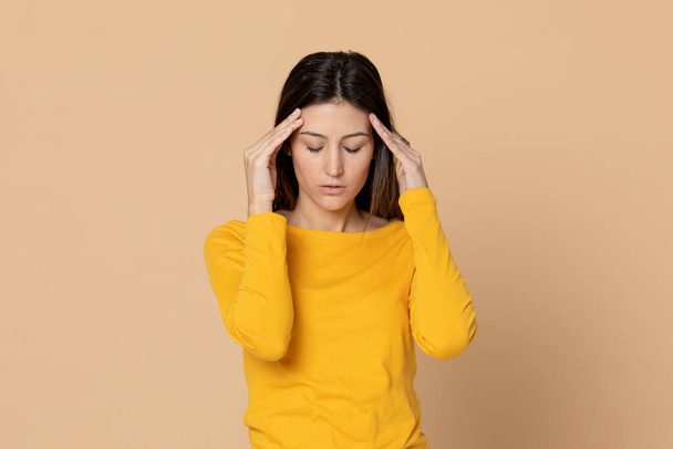Ελκυστική νεαρή κοπέλα φορώντας ένα T-shirt σε κίτρινο φόντο - Φωτογραφία, εικόνα
