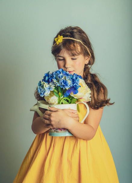indoor studio portrait of child gril with flowers isolated over plain background - Photo, Image