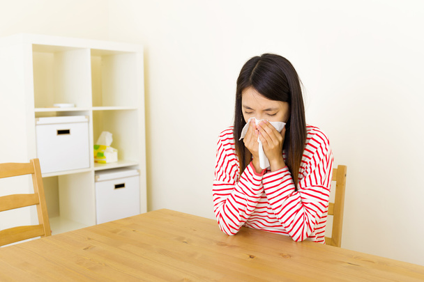 Asiática mujer estornudando en casa
 - Foto, imagen