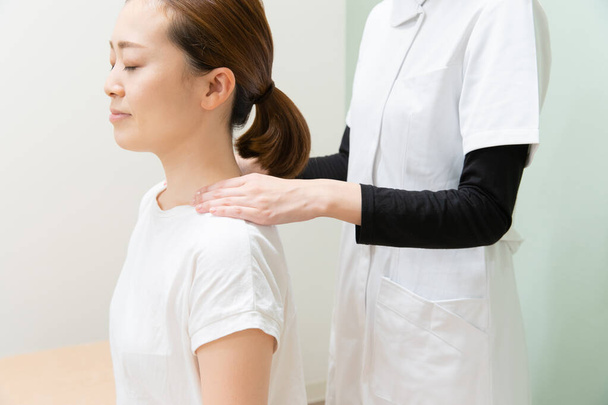 Asiática praticante massageando ombros e pescoço de paciente do sexo feminino
 - Foto, Imagem