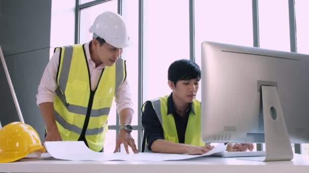 Ingeniero de construcción habla con el personal de dibujo para resolver los problemas estructurales del nuevo edificio de oficinas
. - Metraje, vídeo