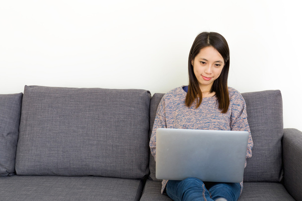 Femme asiatique utilisant un ordinateur portable dans le salon
 - Photo, image