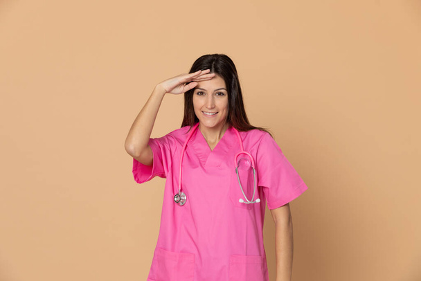 Młody lekarz w różowym mundurze na żółtym tle - Zdjęcie, obraz