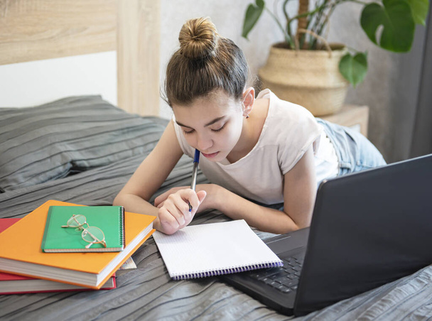 Teen girl uses laptop at home. Distance learning concept.  - Photo, Image
