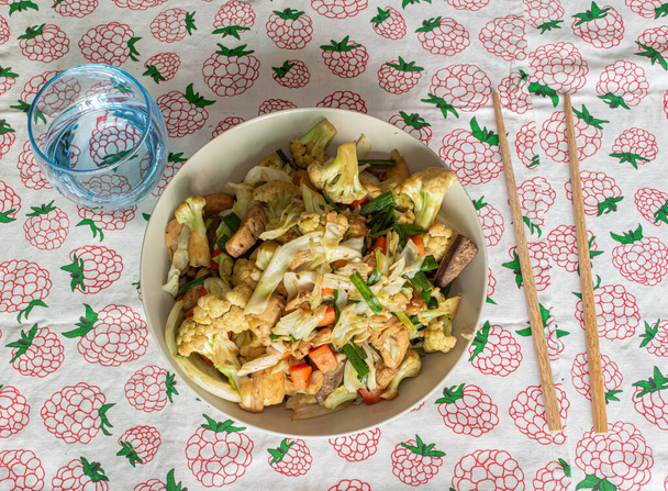 sauté salade, style asiatique cuit. Salade de chou-fleur, poulet, oignon, brocoli et laitue servie dans une assiette
 - Photo, image
