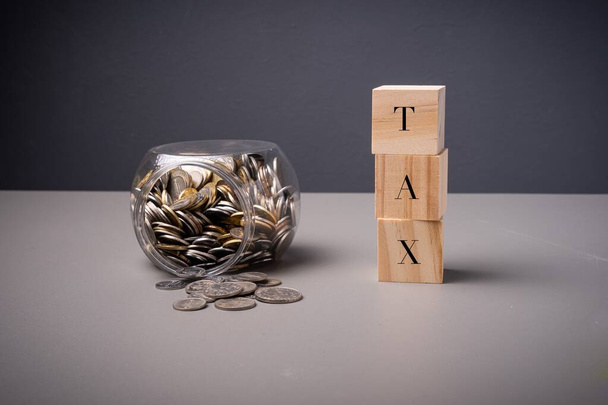 Znění TAX se sklenicí plnou mincí. Koncept daně z příjmu a daně z nemovitostí - Fotografie, Obrázek