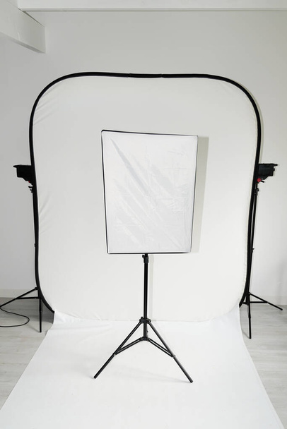 Modern fotoğraf stüdyosunun içi beyaz yumuşak kutu profesyonel ekipmanlarla dolu. - Fotoğraf, Görsel