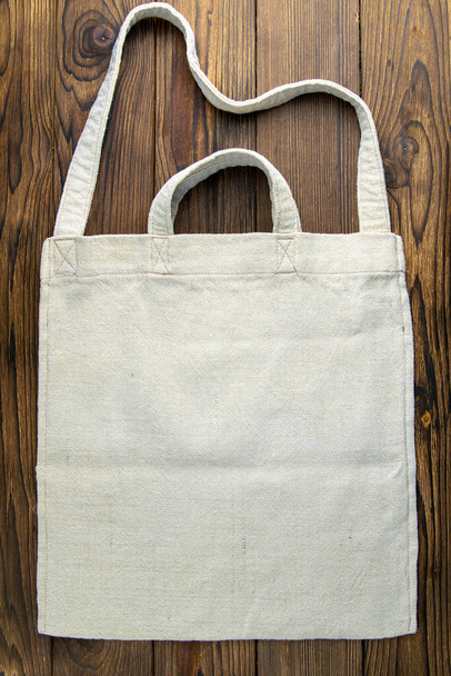 Οικολογικό καμβά ψώνια λευκή τσάντα στο σκούρο ξύλινο φόντο τραπέζι. Top απόψεις με σαφή χώρο. - Φωτογραφία, εικόνα