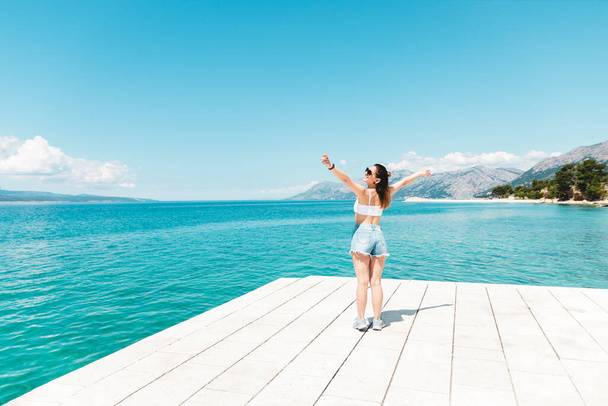 mujer turista en hermosa ubicación viajando después del bloqueo sintiéndose libre disfrutando de la vista de la montaña del mar y el aire fresco
 - Foto, Imagen