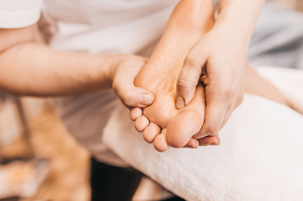 masseur massages actieve punten op de voeten - therapeutische voet massage - Foto, afbeelding