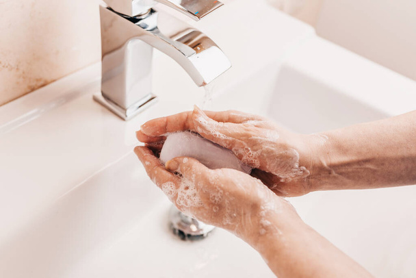 To prevent coronavirus infection, hands should be washed for at least 20-30 seconds, thoroughly cleaning all surfaces on which the virus may be found with soap - Фото, изображение