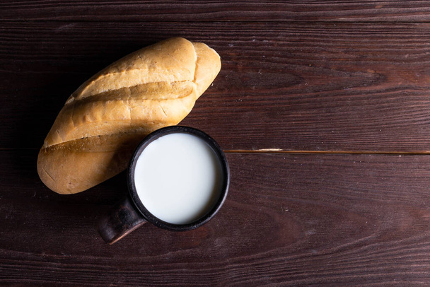 croissant with milk on a wooden table - Fotoğraf, Görsel