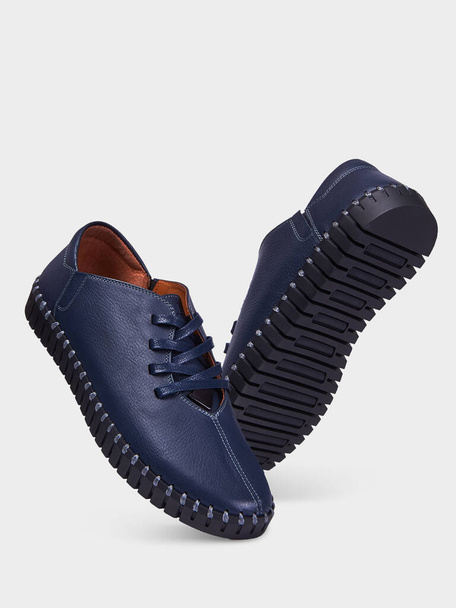 Niebieskie buty męskie z perforacją i elastyczną czarną podeszwą. Izolacja na białym tle. - Zdjęcie, obraz