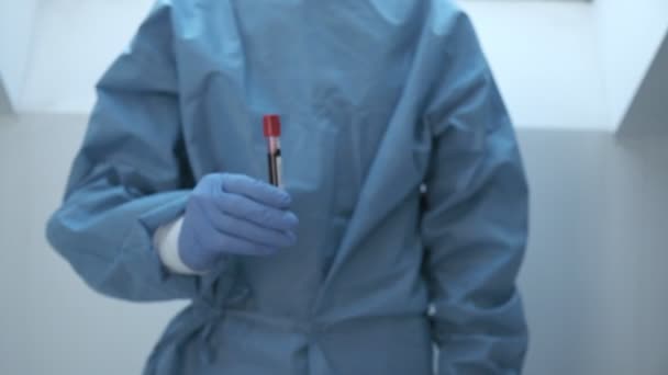 microbioloog, medisch werker hand met blauwe handschoenen tonen bloedonderzoek resultaat - Video