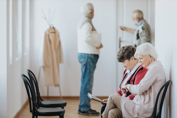 Older people waiting in a line in a clinic to the doctor's office - Valokuva, kuva