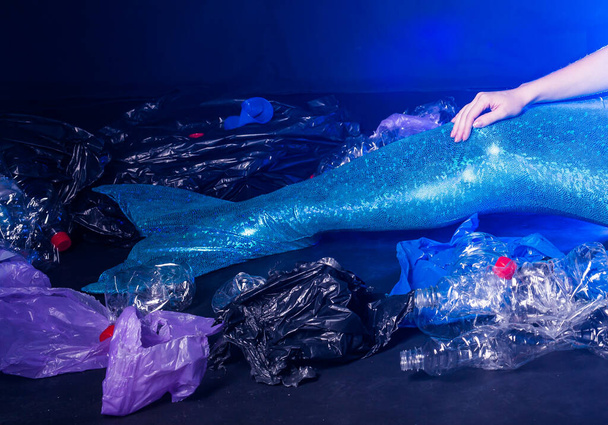 Ocean pollution, rubbish in the water. Close-up fairytale mermaid in dirty ocean. Plastic trash and garbage in water. Environmental problem, plastic bag and bottles polluting planet. - Photo, Image