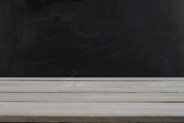 Серый деревенский столешница против черной стены доски
. - Фото, изображение