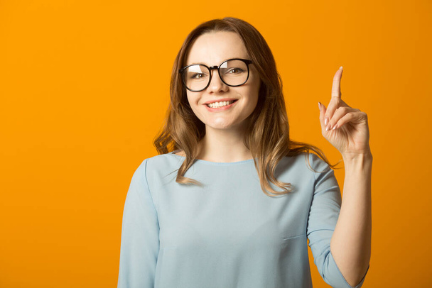 beautiful young woman in dress on yellow background with hand gesture - Φωτογραφία, εικόνα