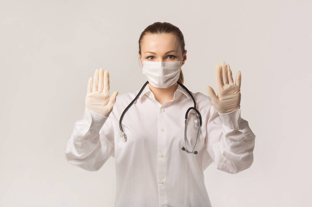 beautiful young woman in medical face mask on a white background - Fotó, kép