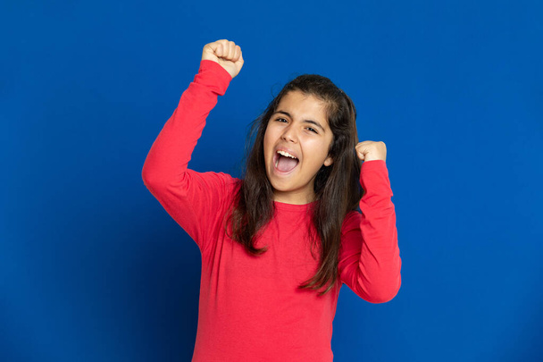 Adorable preteen girl with red t-shirt i on a blue background - Photo, Image
