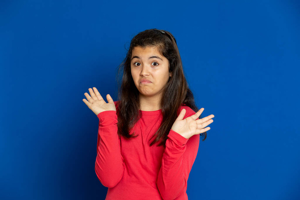 Очаровательная девочка-подросток в красной футболке i на синем фоне
 - Фото, изображение