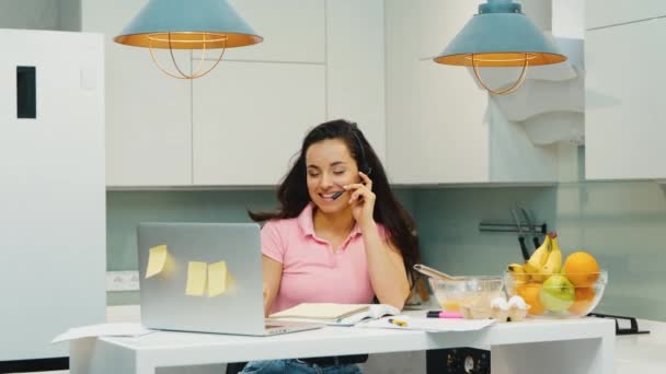 Mladá žena pracuje doma během karantény. Multitasking dívka dokončuje rozhovor na video hovoru a dát sluchátka na notebook.Going odpočinek po náročném pracovním dni. - Záběry, video