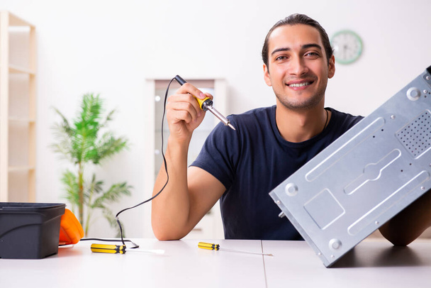Young man repairing computer at home - Foto, immagini