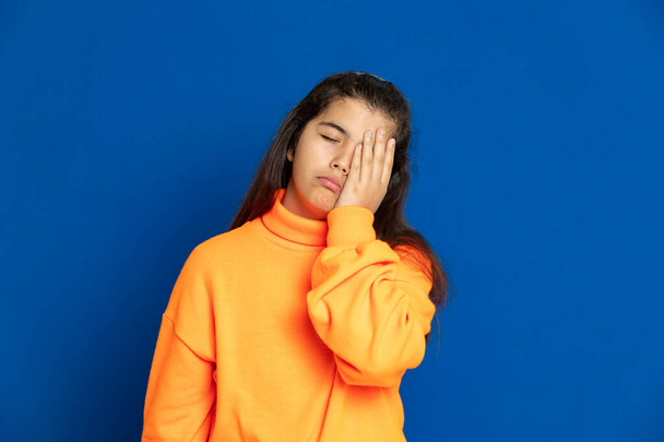 Adorable preteen girl with yellow jersey on a blue background - Fotografie, Obrázek