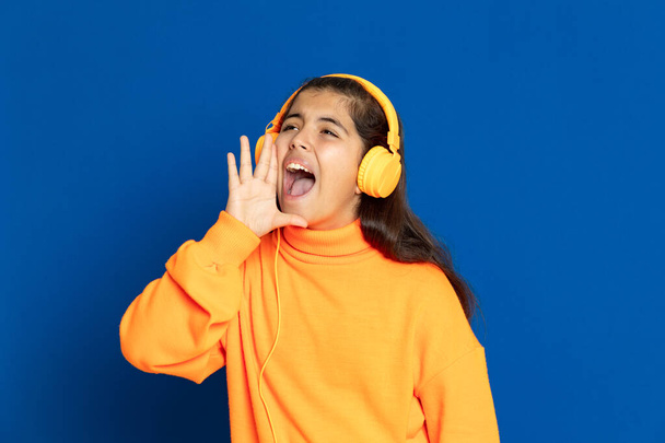 Urocza nastolatka w żółtej koszulce na niebieskim tle - Zdjęcie, obraz