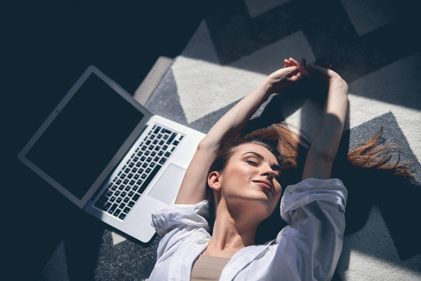 Attractive female freelancer stretching after studying online from home - Valokuva, kuva