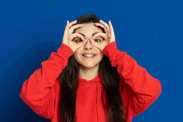 Bruneta mladá dívka nosí červený dres na modrém pozadí - Fotografie, Obrázek