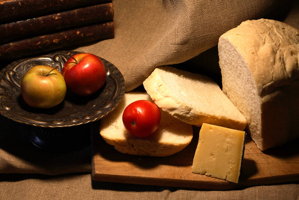 Sliced loaf of white bread near cheese and fruits on canvas background - Valokuva, kuva