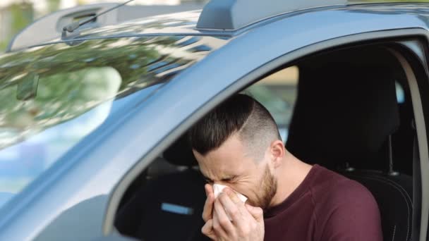 Young man inside car. Sick ill hipster sneezing into white tissue and suffer. Wipe nose and eyes from tears. Coronavirus symptoms. Slow motion. - Footage, Video