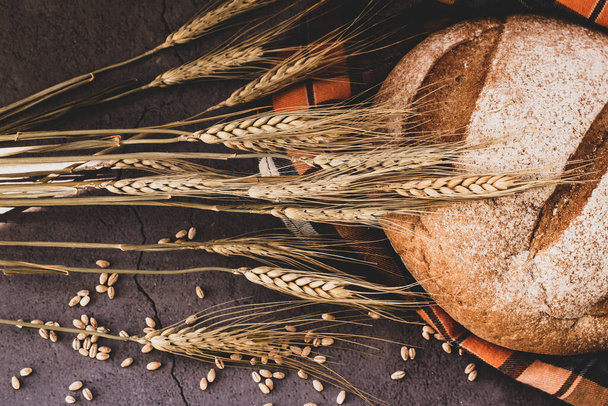 Weizenspitzen und frisches Brot auf dem Tisch - Foto, Bild