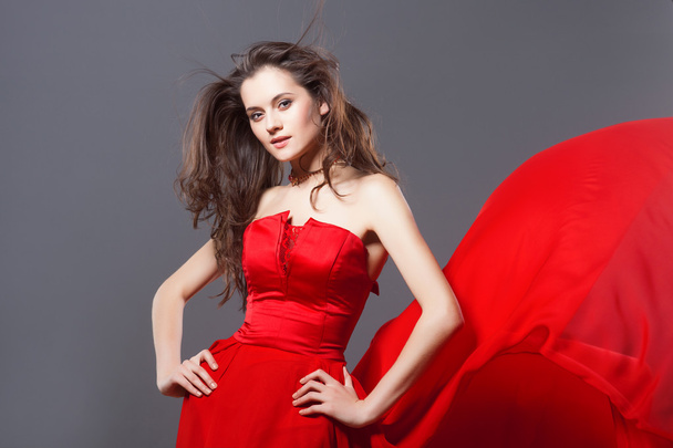Sexy woman in fluttering red dress - Фото, зображення