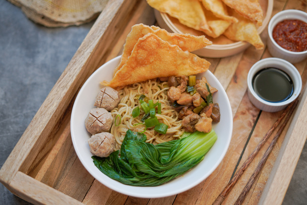 Nourriture indonésienne, mie ayam, nouilles au poulet et servi avec boulettes de viande et wonton pangsit frit
 - Photo, image