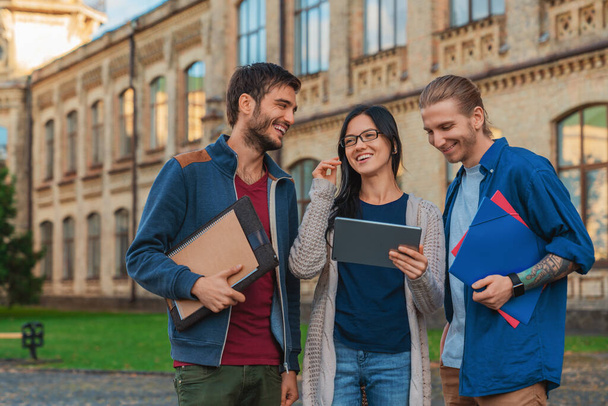Multi ethnic group of student in university smiling and looking at the tablet - Foto, Bild