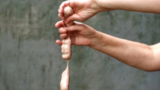 Preparations homemade sausages. Step by step. Raw bunch sausages are greased manually with fat or cooking oil and crumple for better distribution of minced meat. Close up. - Footage, Video