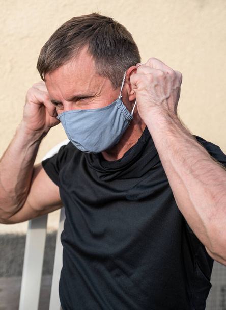 Healthcare and medicine concept. Portrait of man wearing protective mask outdoors to prevent coronavirus, covid-19, germs, toxic fumes and dust - Photo, Image