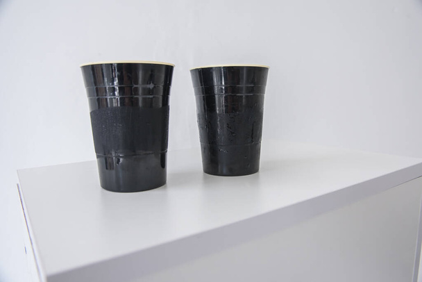 vasos oscuros para bebidas sobre una superficie clara
 - Foto, Imagen