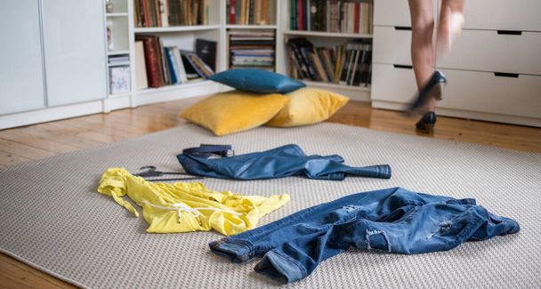 pièces jaunes et bleues de vêtements sur le sol femme se déshabiller
 - Photo, image
