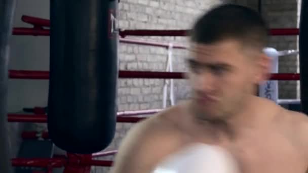Close-up Strong Muscular Man Fiercely Punching Punch Bag at Urban Gym. Professional Boxer powerful hand thrusts - 映像、動画