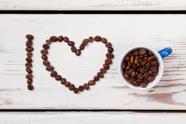 Κόκκοι καφέ οργανωμένοι σε σχήμα καρδιάς. - Φωτογραφία, εικόνα