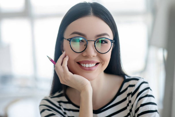 Dark-haired pretty woman in eyeglasses smiling nicely - Photo, image