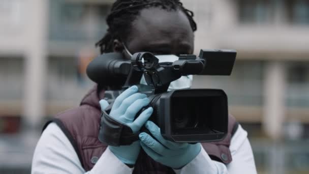 Αφρικανός κάμεραμαν καταγράφει ειδήσεις με επαγγελματική κάμερα. Αναφορά για την πανδημία του Coronavirus  - Πλάνα, βίντεο
