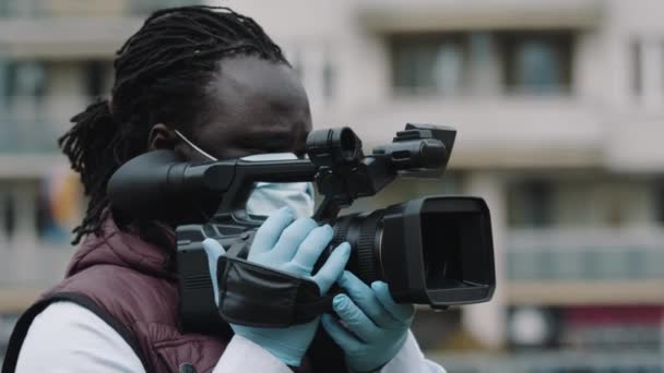 Afrikaanse cameraman opname met professionele camera. Rapportage over de uitbraak van het coronavirus - Video