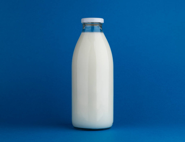 Glass milk bottle mock up on blue background - Fotoğraf, Görsel