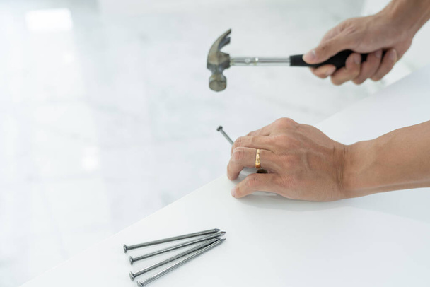 Handyman marteler un clou pour la maison avec panneaux de revêtement, travaux de construction et service de rénovation
 - Photo, image