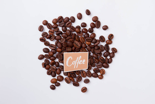 Haufen verstreuter Kaffeebohnen isoliert auf weiß. - Foto, Bild