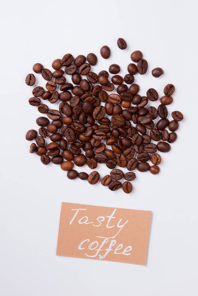 Top view heap of roasted coffee beans on white background. - Photo, Image